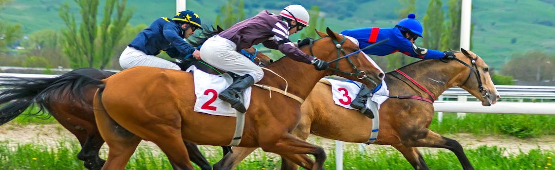 Three jockeys on horses galloping