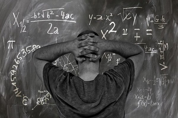 Man looking at board with maths equations