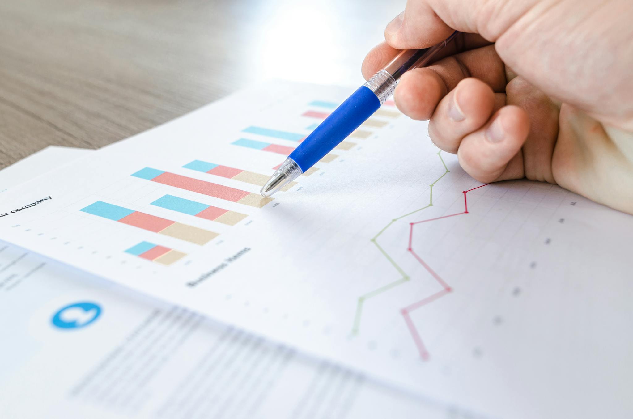 Laptop displaying charts and graphs with tablet calendar for data analysis and planning.