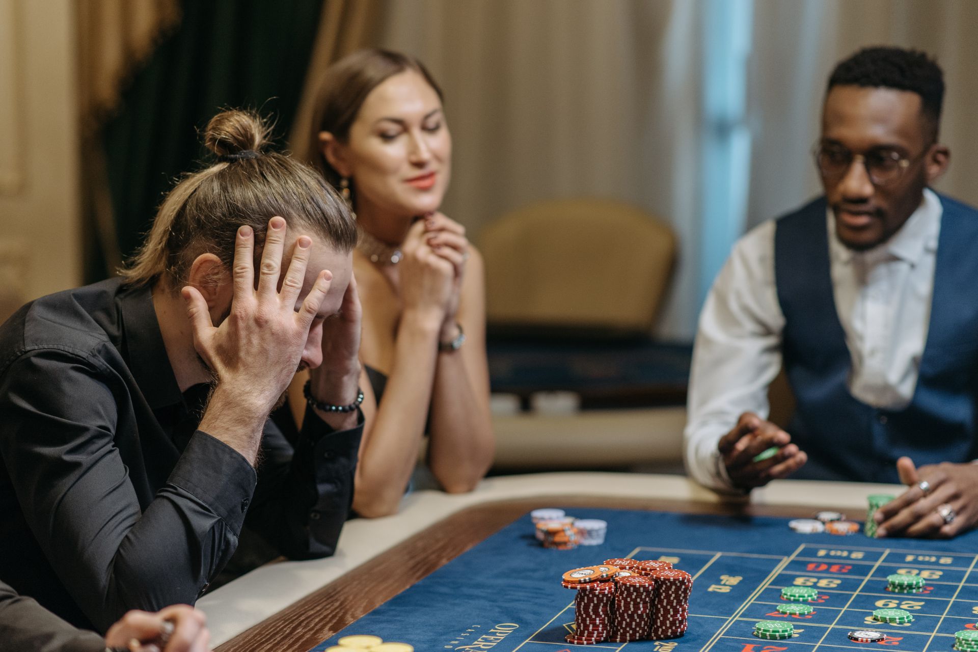 Man holding head in hands at casino table - featured image of gambler's fallacy article