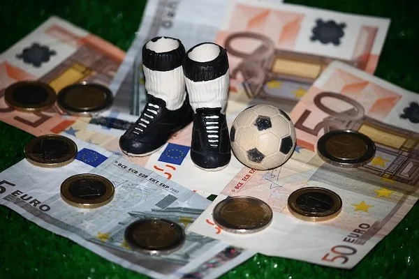 Coins, money notes, football boots and a football