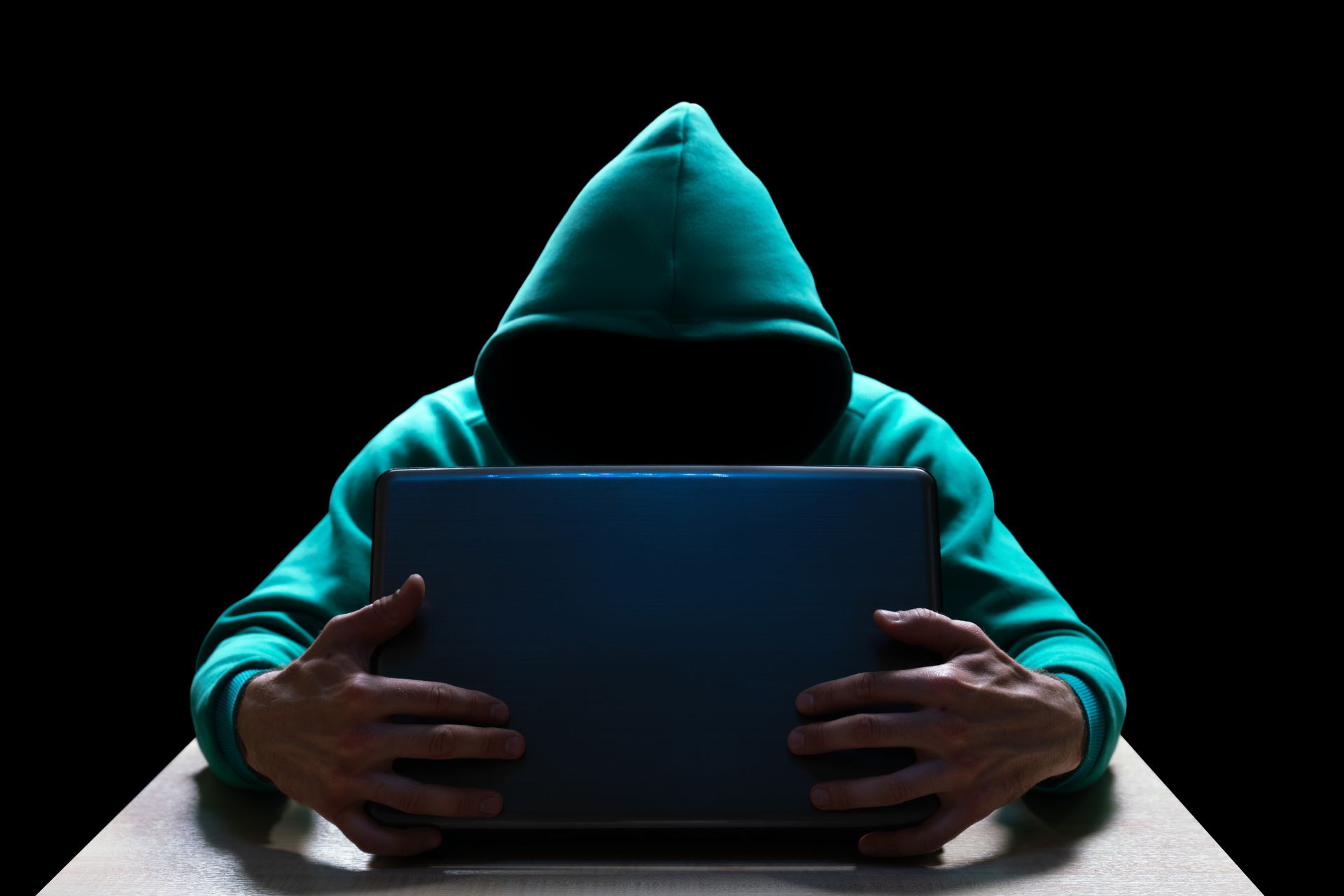 Sinister looking hooded person with face hidden behind laptop, as featured image for how to avoid sports tipster scams